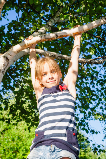 istock Happy girl hanging from a tree in a summer park 1093971772