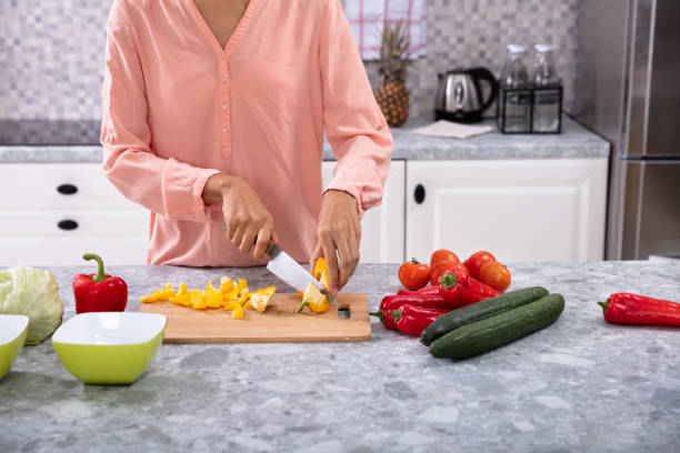 istock Woman's Hand Cutting Bell Pepper With Knife 1093972124