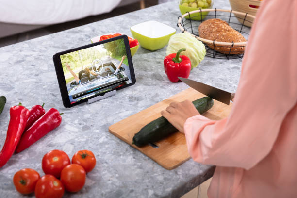 istock Woman Enjoying The Video While Cutting Cucumber 1093972136