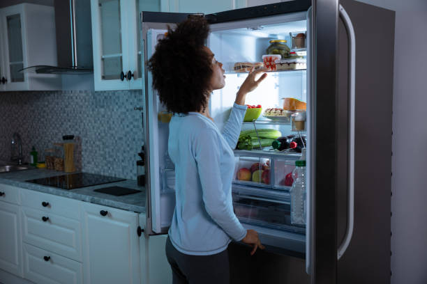istock Woman Searching Food In Refrigerator 1093972196