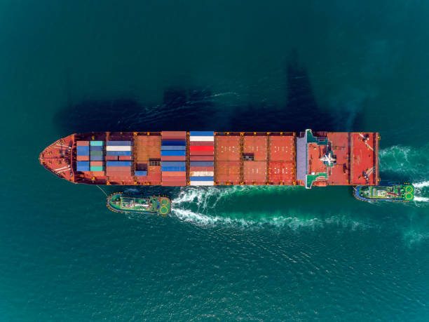 istock Aerial top view Tug boat drag Container ship to container warehouse or crane bridge for loading container for logistics import export, shipping or transportation background. 1093972950
