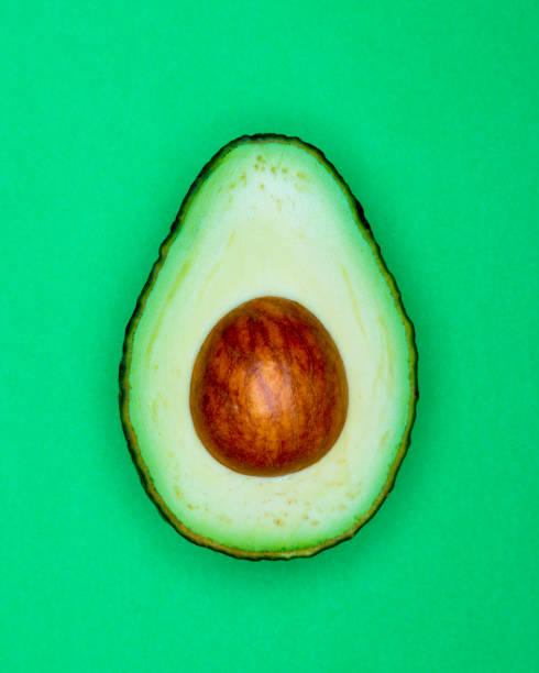 istock Half Avocado pop Art style centred from above bright green coloured background 1093975566