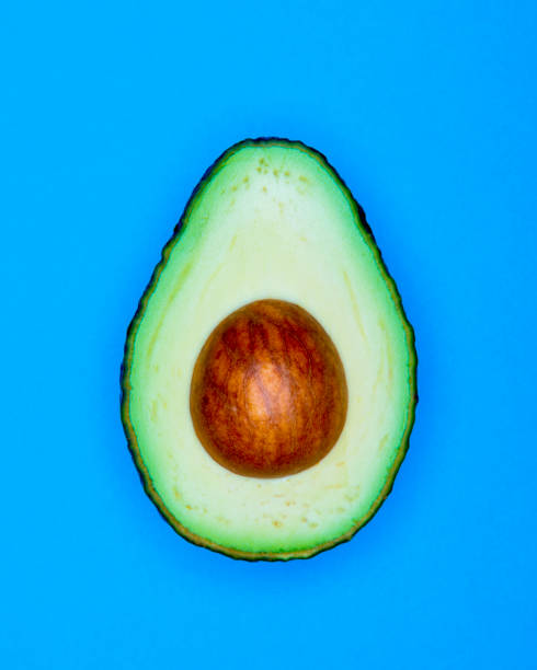 istock Half Avocado pop Art style centred from above bright  blue coloured background 1093975694