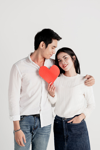 Happy young couple is holding red paper hearts,love story Valentine's Day