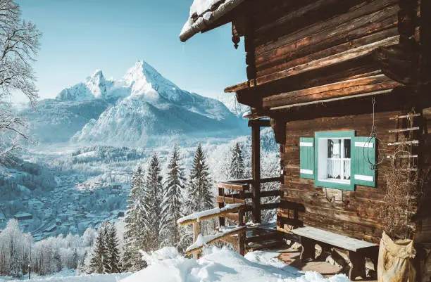 Beautiful view of traditional wooden mountain cabin in scenic winter wonderland mountain scenery in the Alps