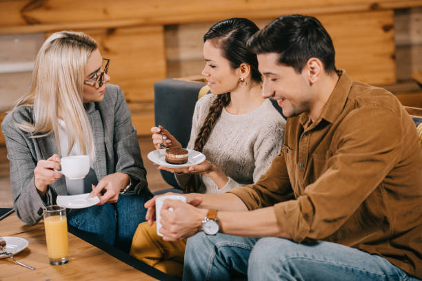 istock smiling woman chatting with friends while holding cake in cafe 1093984478