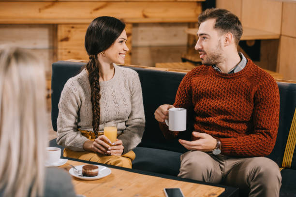 istock selective focus of smiling friends chatting in cafe 1093984520