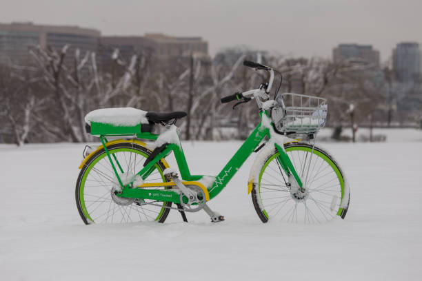 Abandoned bike share e-bike in a snow covered parking lot stock photo