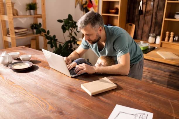 istock Little son trying to type on fathers laptop 1093991554