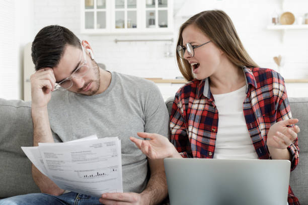 istock Young woman shouting desperately at man while counting debts for bills, experiencing family budget crisis 1093991756