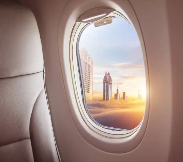 Airplane interior with window view of Dubai city, UAE. Concept of travel and air transportation