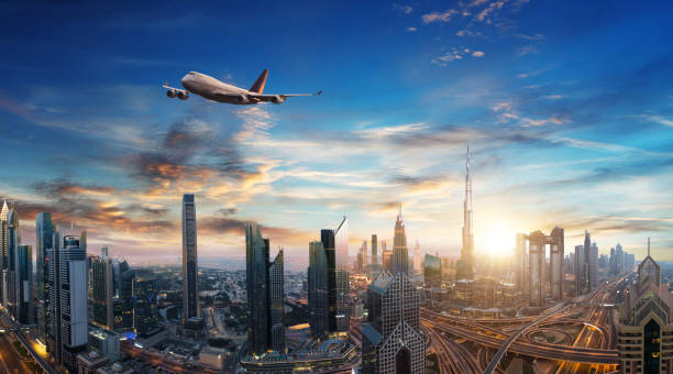 Commercial jet plane flying above Dubai city Commercial airplane flying above clouds and Dubai city, in beautiful sunset light. Modern and fastest mode of transportation, business life. Very high resolution image khalifa stock pictures, royalty-free photos & images