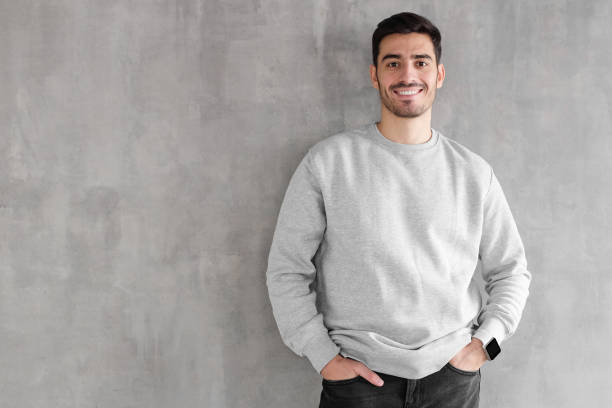 istock Young man in oversized sweatshirt isolated on textured gray wall background with copy space for your design 1093998506