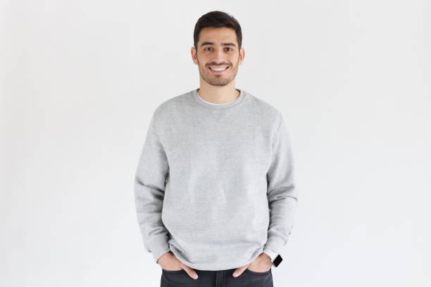 Young handsome man in oversized sweatshirt, standing isolated on gray background Young handsome man in oversized sweatshirt, standing isolated on gray background sweatshirt stock pictures, royalty-free photos & images