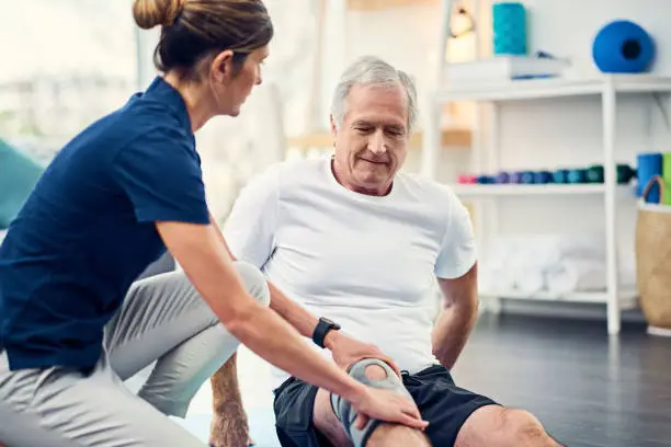 Cropped shot of an attractive young female physiotherapist working with a senior male patient