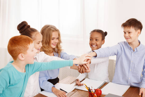 istock Children putting their hands together in classroom 1094001706