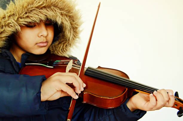 istock Bright Horizontal capture of a boy with lovely lips playing the stringed and bowed musical instrument, the violin 1094007984