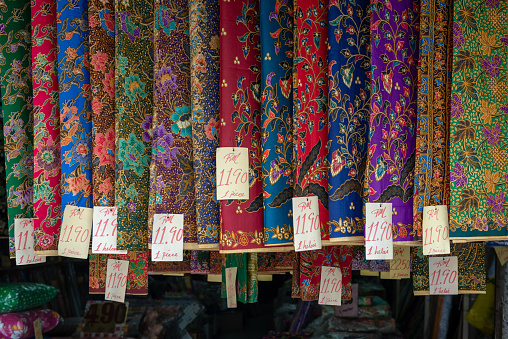 The row of traditional Malaysian (Peranakan) colorful textile with price tags in the shop display.