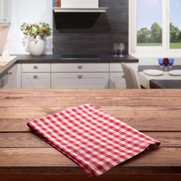 istock Empty wooden table with red checkered tablecloth near the window in kitchen. Red checkered Napkin close up top view mock up. Kitchen rustic background. 1094011672