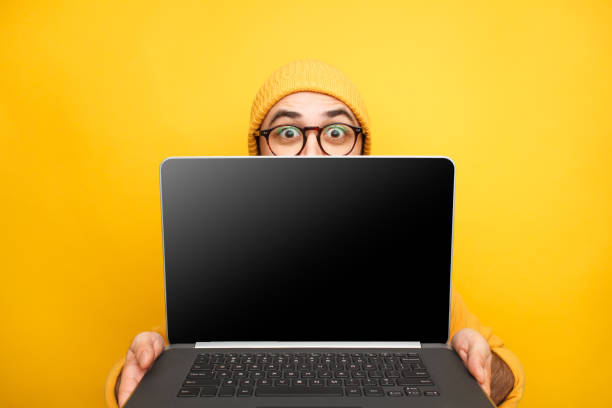 istock Playful man offering modern laptop 1094012828