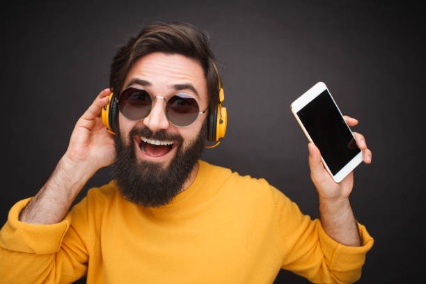istock Excited man with smartphone and headphones 1094012834