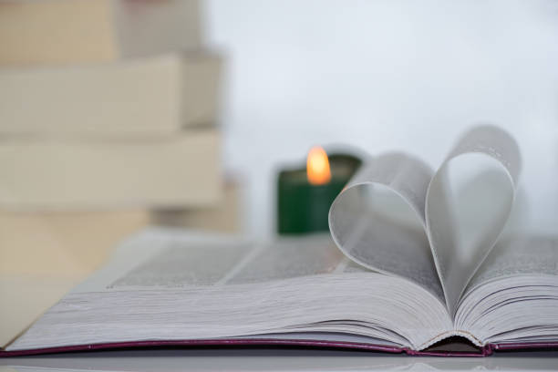 istock heart shape from paper book against blurry green candle 1094016076