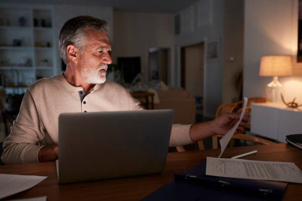 istock Senior Hispanic man checking his finances online at home using a laptop computer at night 1094018126