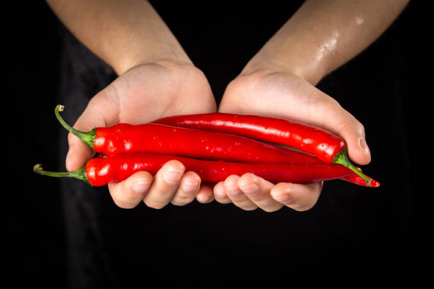 istock Wet the red chilli pepper in woman hands 1094024654