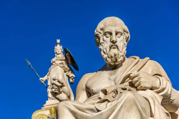 Statue of the Greek philosopher Plato in front of the Academy of Athens, with Athena statue in background, Greece