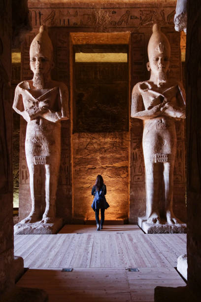 abu simbel - reisenden im inneren tempel in ägypten sieht klein im vergleich zu statuen - abu simbel stock-fotos und bilder