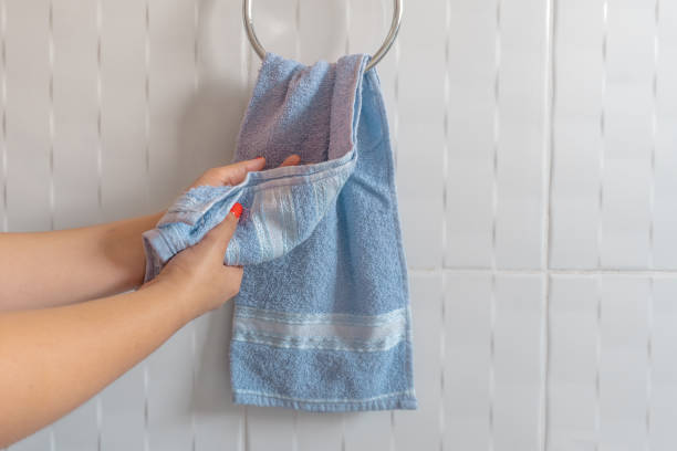 Woman drying hands with blue towel stock photo