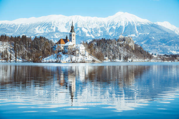 bleder see mit bleder insel und schloss bei sonnenaufgang im winter, slowenien - castle slovenia winter snow stock-fotos und bilder