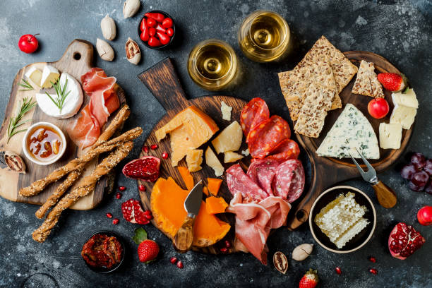istock Appetizers table with italian antipasti snacks and wine in glasses. Brushetta or authentic traditional spanish tapas set, cheese variety board over black stone background. Top view, flat lay 1094050542