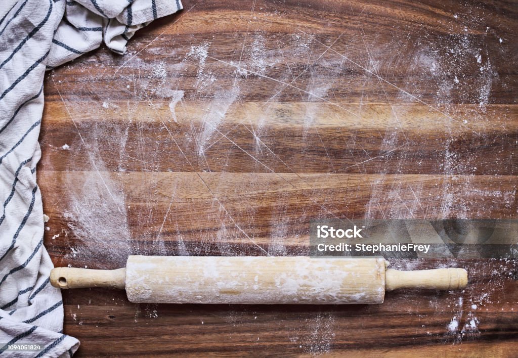 Floured oak table with rolling pin and towel Floured oak table with rolling pin and towel and room for text. Top view. Flour Stock Photo