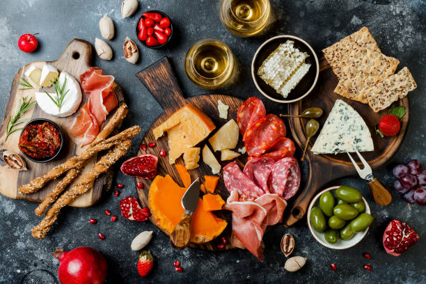 istock Appetizers table with italian antipasti snacks and wine in glasses. Brushetta or authentic traditional spanish tapas set, cheese variety board over black stone background. Top view, flat lay 1094053018