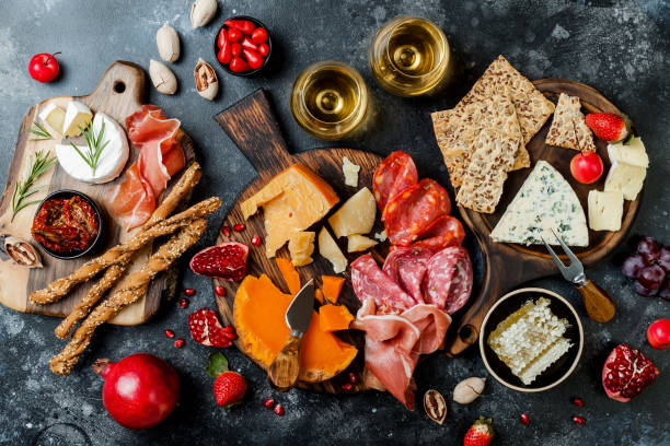istock Appetizers table with italian antipasti snacks and wine in glasses. Brushetta or authentic traditional spanish tapas set, cheese variety board over black stone background. Top view, flat lay 1094053708