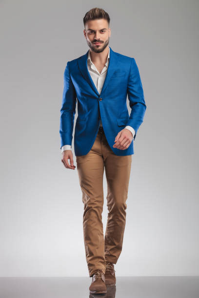 istock young smart casual man in blue suit walks forward 1094054486