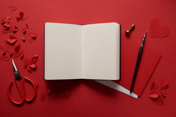 istock top view of paper cut hearts, scissors and empty notebook on red background 1094054980