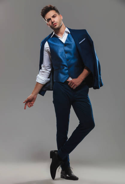 istock gentleman wearing blue suit on shoulders standing with legs crossed 1094057772