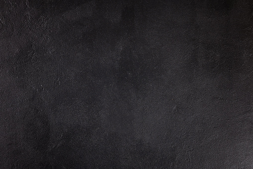 The texture of concrete. Fragment of black concrete. Top view. Painted texture. Concrete background