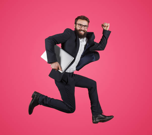 istock Stylish man with laptop running fast 1094061938