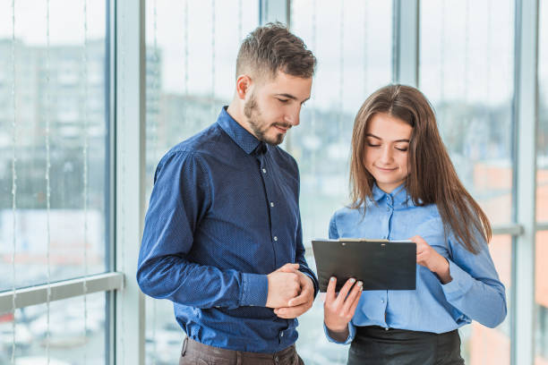 istock The secretary has brought a folder with documents for signature. During this they are all dressed in business clothes. 1094081126