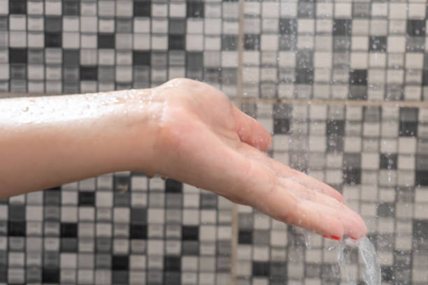 istock Soft selective focus of hands and droplets of water from shower with pattern background 1094082318