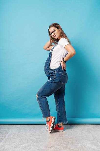 istock A pregnant young woman having a back ache standing over blue background in the studio 1094082466