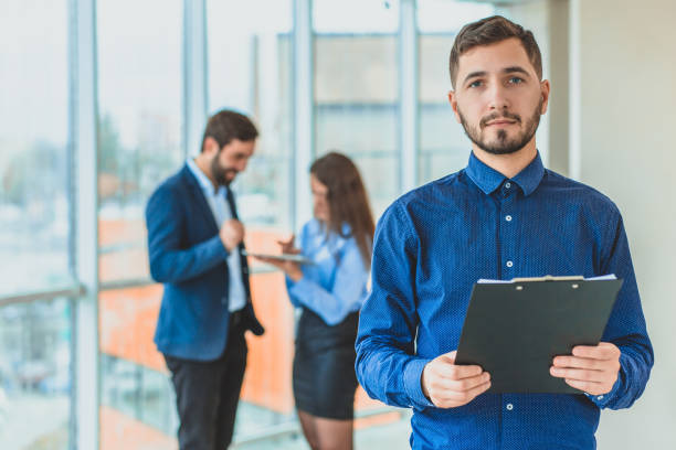 istock A businessman is standing in the office holding a folder in his hands 1094084000
