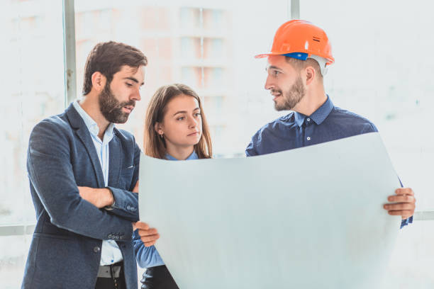 istock An architect in an orange box office is standing next to their business partners 1094085572