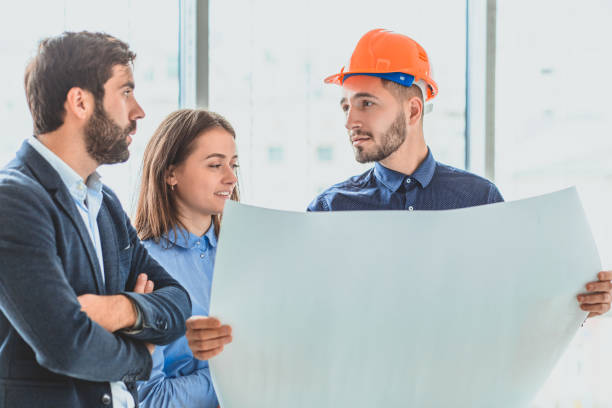 istock An architect in an orange box office is standing next to their business partners 1094085654