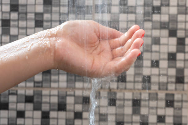 istock Soft selective focus of hands and droplets of water from shower with pattern background 1094086822