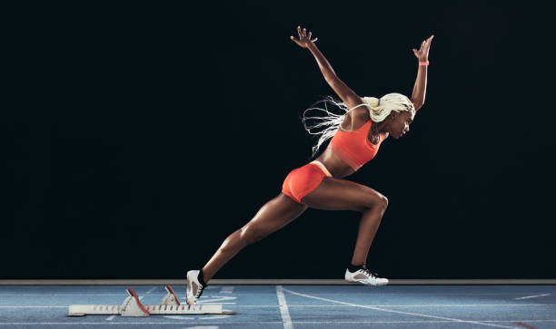istock Woman athlete taking off from starting block on a running track 1094087376