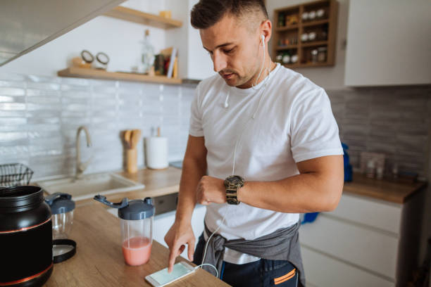 Young man synching smartphone app with smart wear device